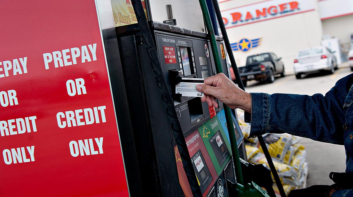 Customer using a card reader at a diesel fuel pump payment terminal
